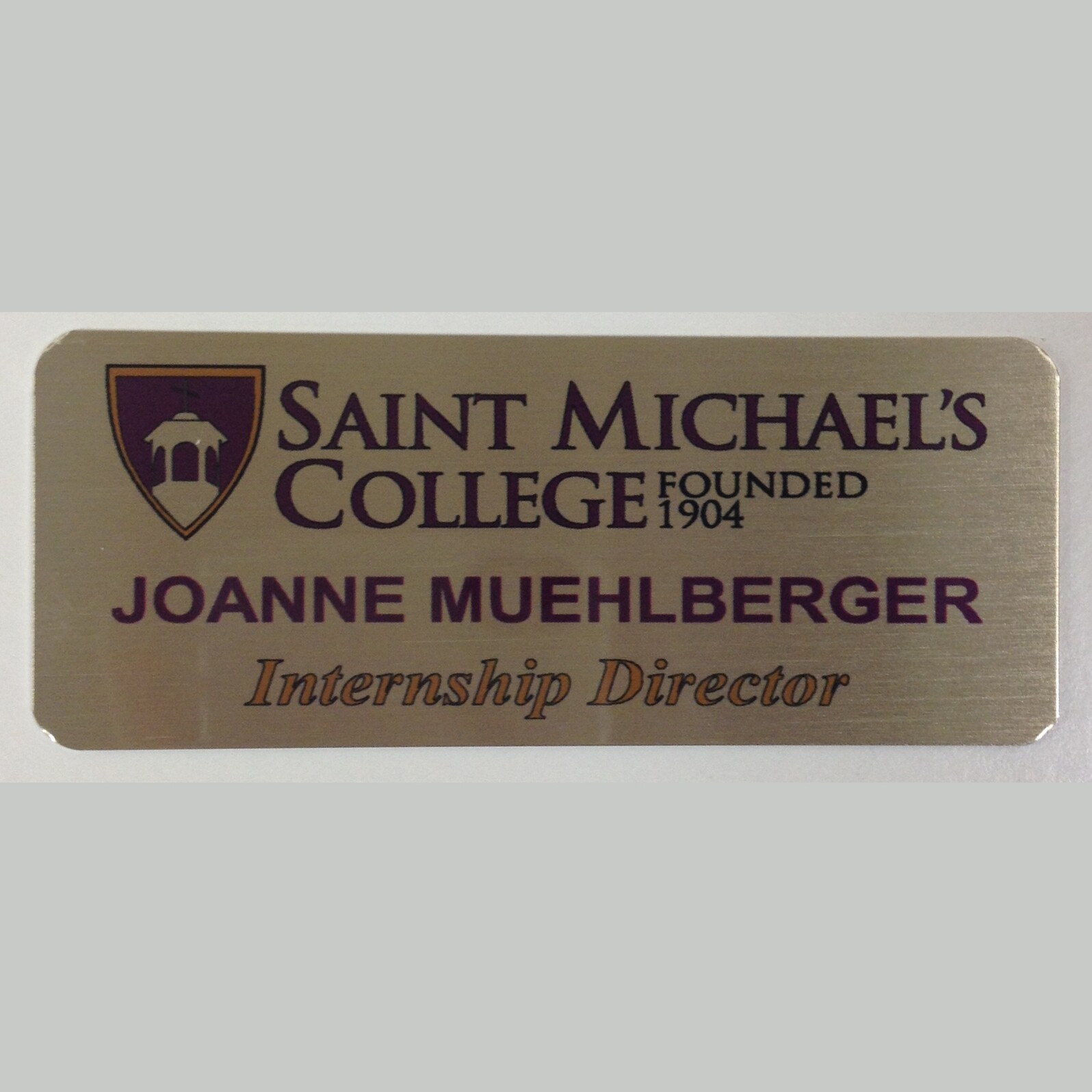 1.5x3 gold aluminum name tag with St. Michael's College logo